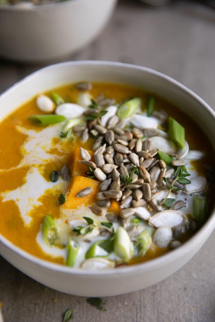white bowl full of Healthy Curry Lentil Soup covered with seeds