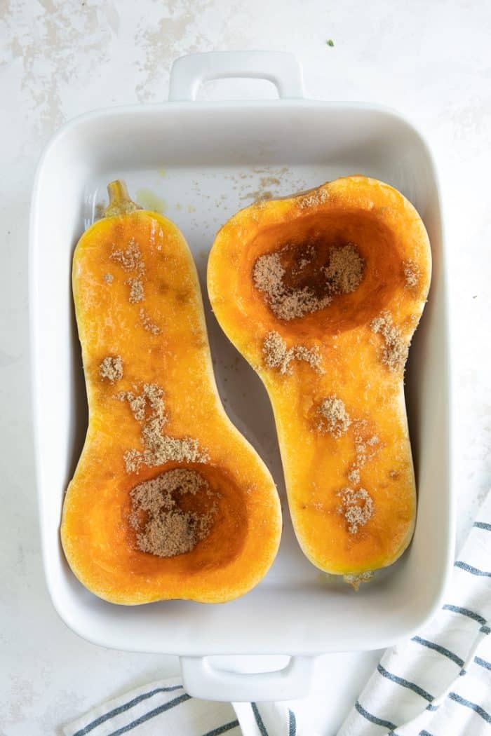Butternut squash in baking pan sprinkled with brown sugar