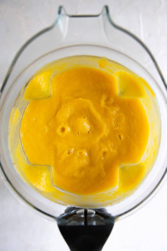 Blender filled with pureed butternut squash soup.