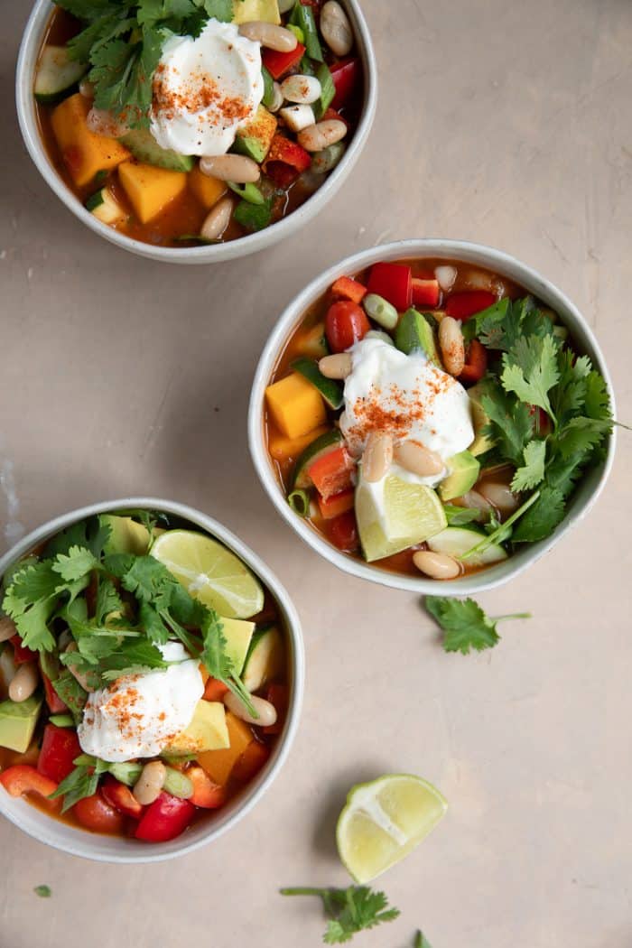 Overhead image of three white bowls filled with vegetarian butternut squash chili.