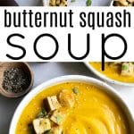 Overhead view of creamy butternut squash soup served in a white bowl, topped with homemade croutons, fresh herbs, and seeds, surrounded by small bowls of black pepper and salt.