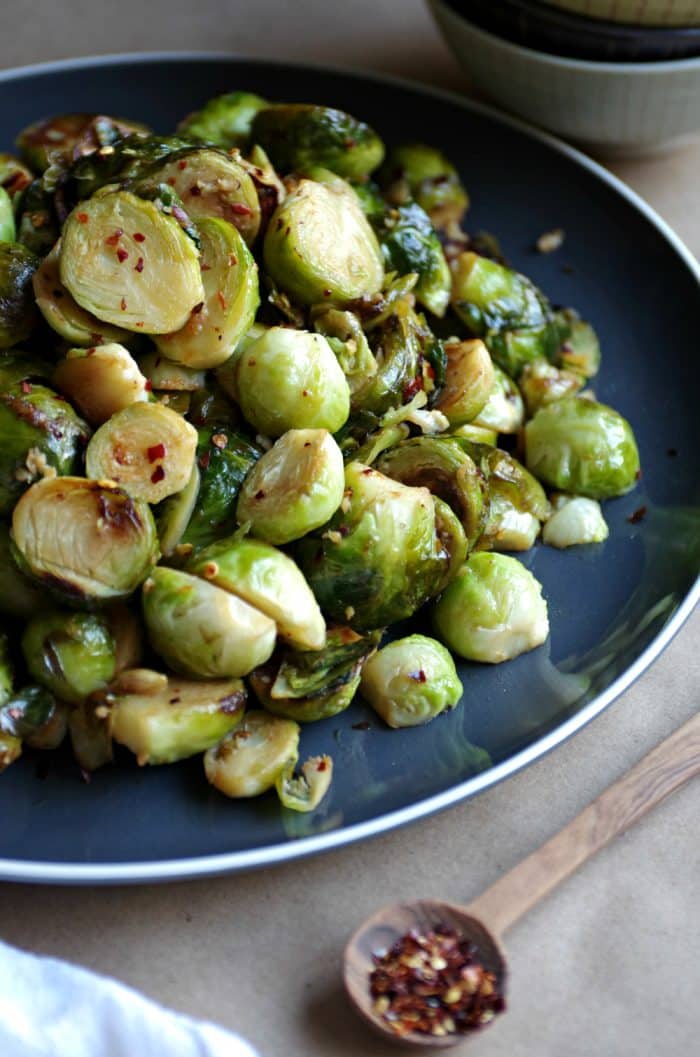 Sautéed Brussels Sprouts with Lemon and Garlic on a black serving plate
