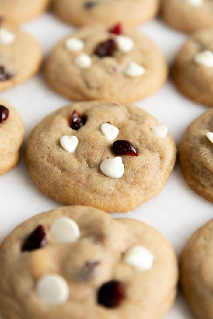 Fluffy baked golden cookies topped with white chocolate chips and dried cranberries.
