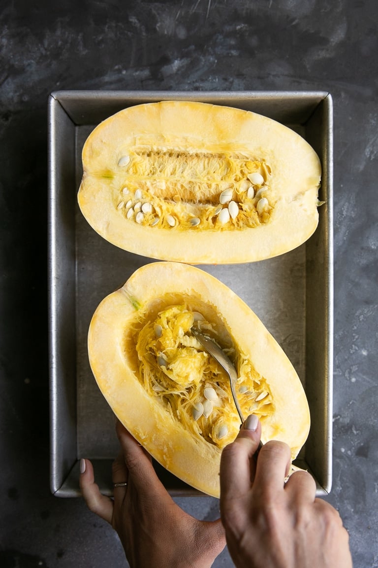 removing seeds from a halved and uncooked spaghetti squash