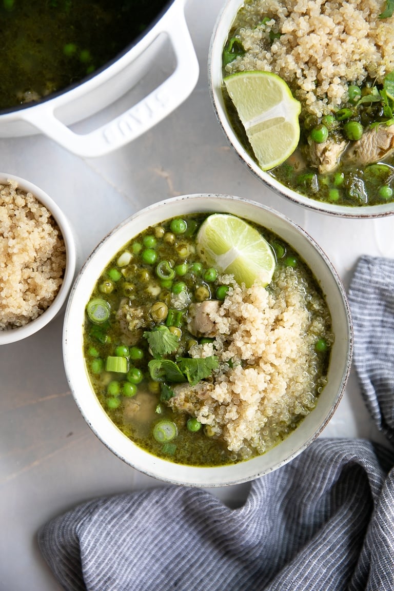 Overhead image of pot and bowls filled with Aguadito de Pollo (Peruvian Chicken Soup).