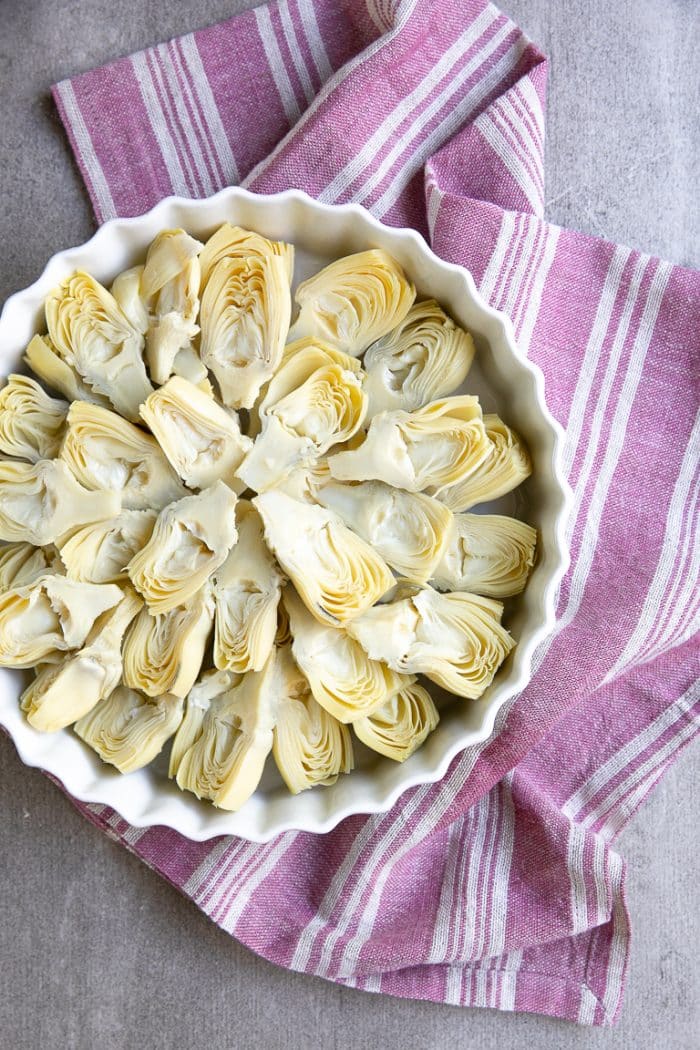 Tart pan filled with halved artichoke hearts