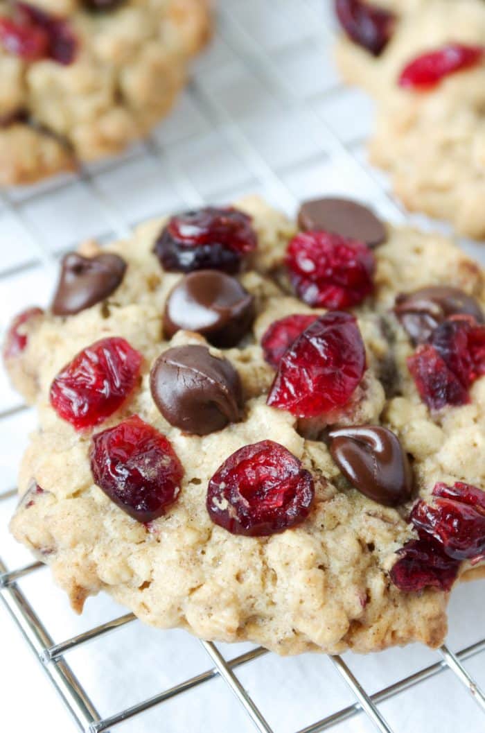 Close up image of an oatmeal cookie made with chocolate chips, dried cranberries, and pecans.