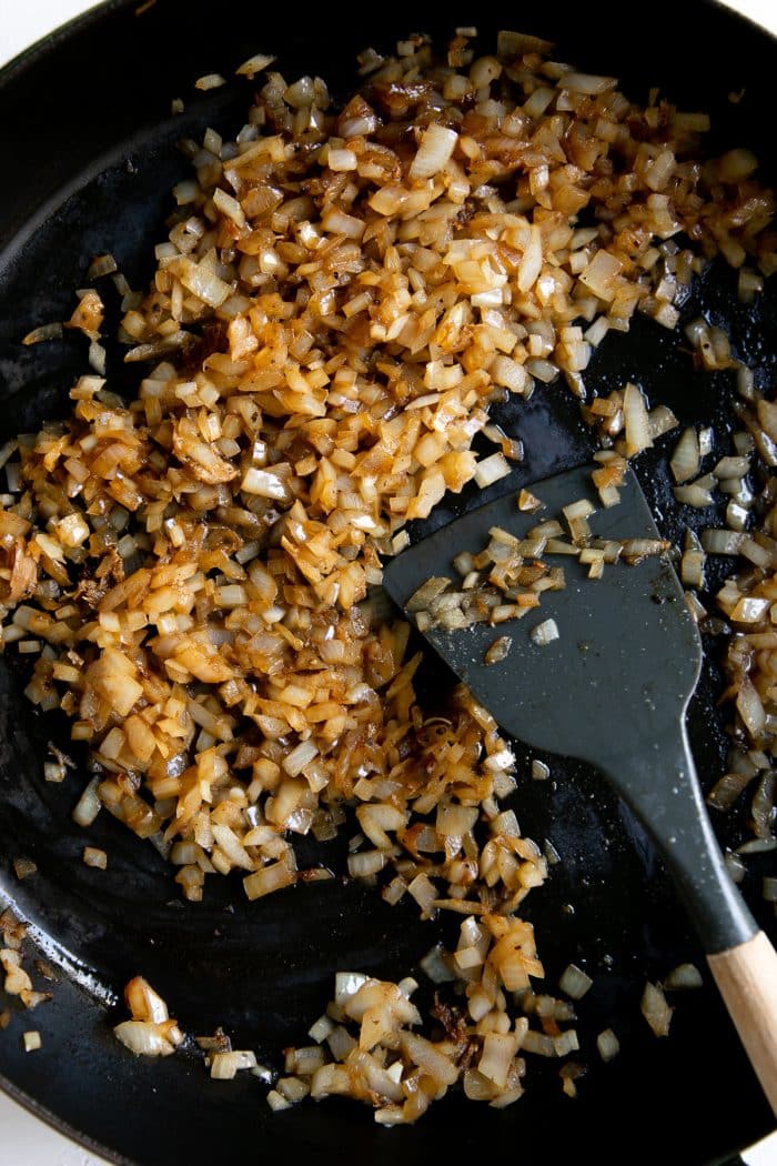 Finely minced onions caramelizing in a large skillet.