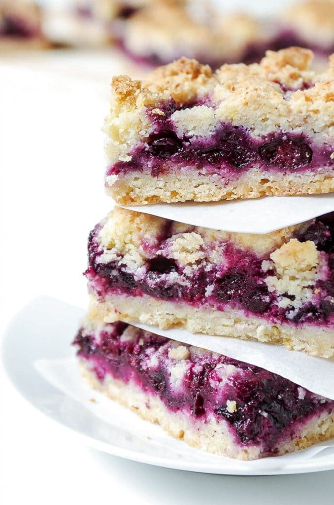 Three stacked Blueberry Crumb Bars on a white plate