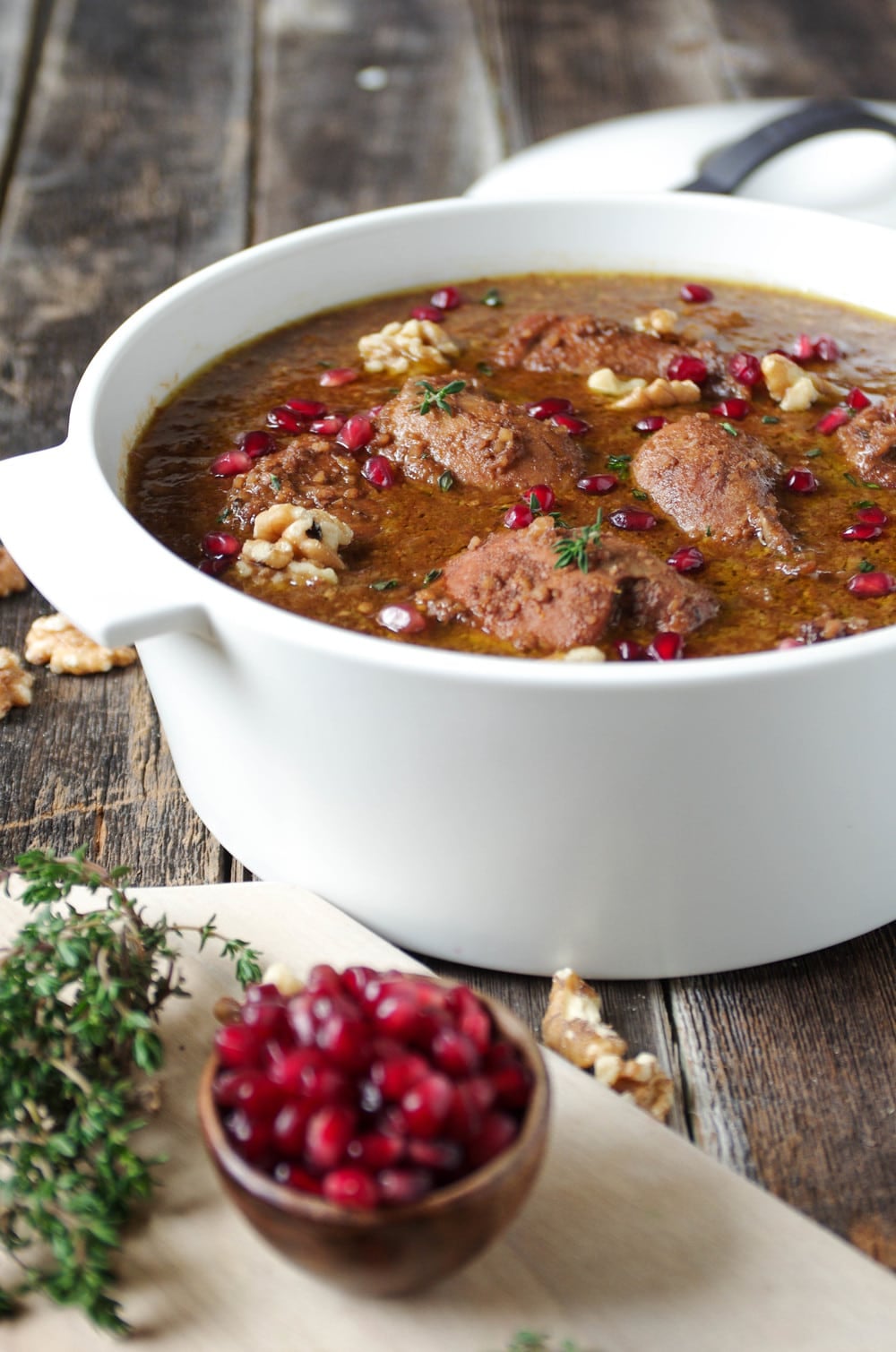 Large white Dutch oven filled with cooked Persian Pomegranate and Chicken Stew (Fesenjān)