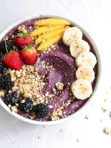 Acai bowl topped with fresh fruit and granola.