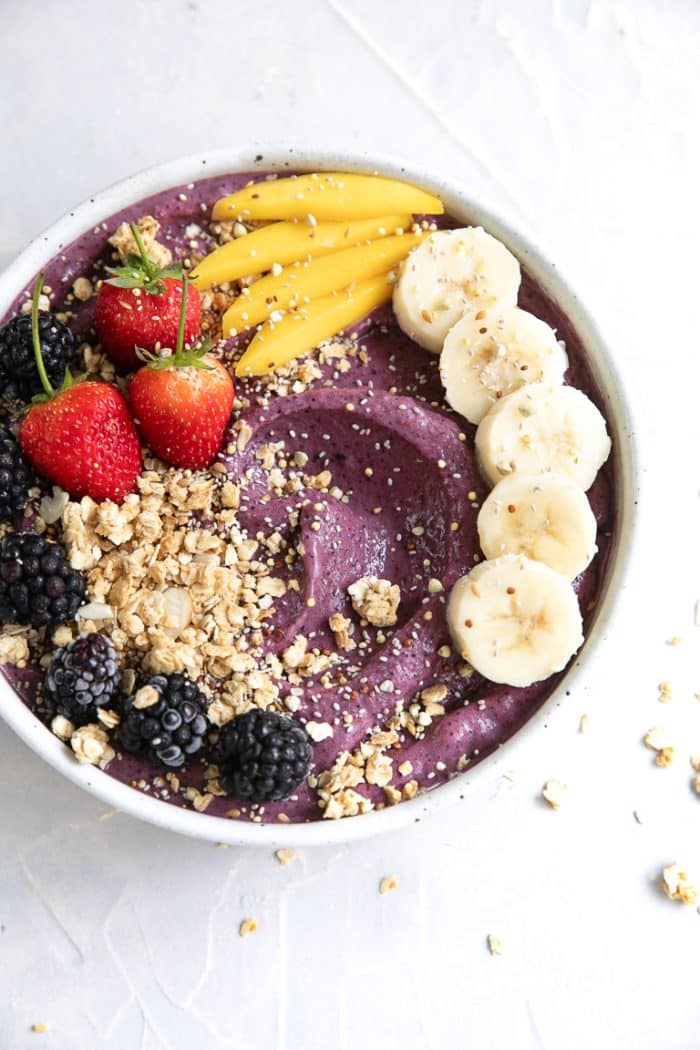 Acai bowl topped with fresh fruit and granola.