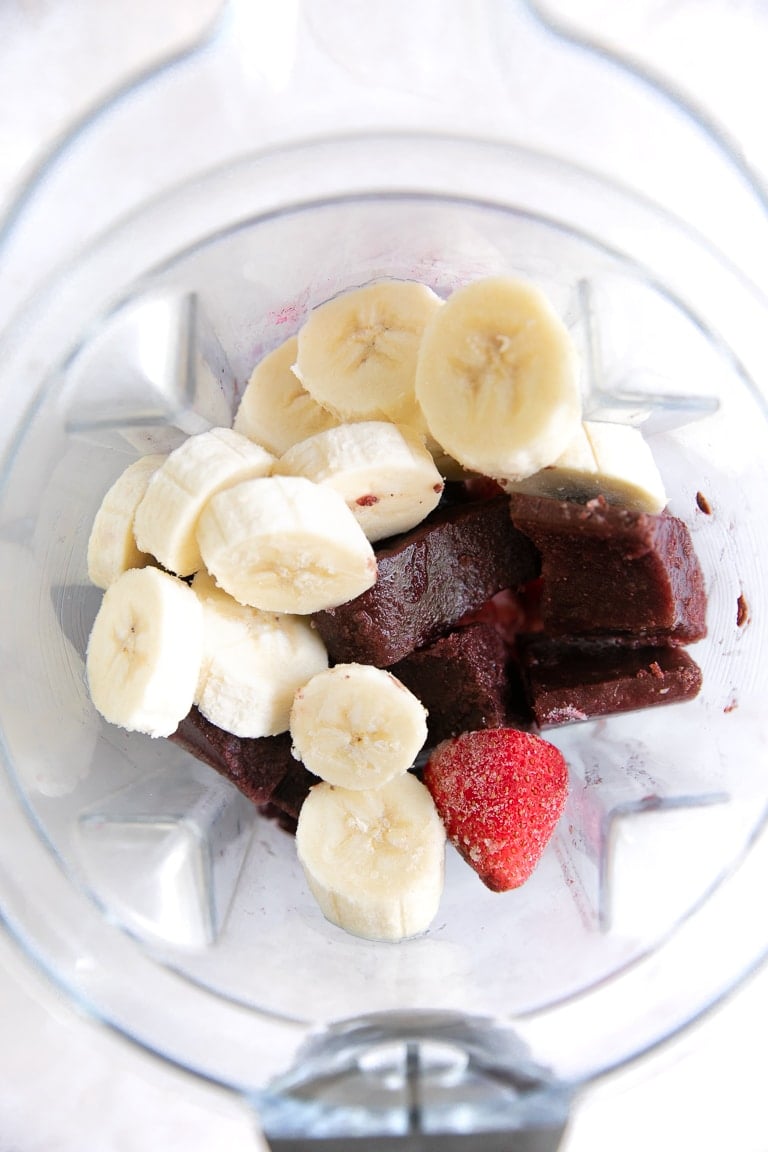 banana slices, frozen acai, and strawberries in a blender