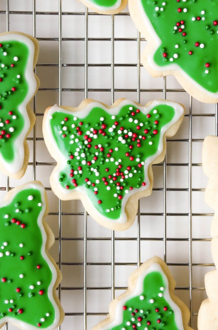 Christmas Tree sugar cookies on a wire cooking rack decorated with green frosting.