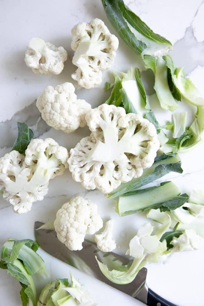 Chopping a large cauliflower into smaller florets.