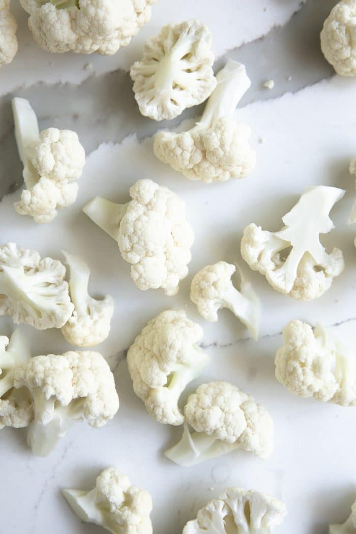 Cauliflower florets on a large marble slab.
