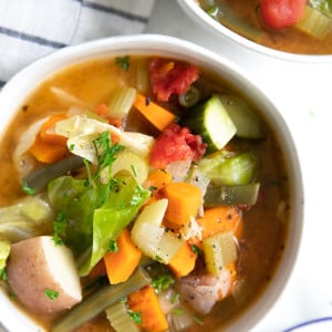 Large white soup bowl filled with a brothy vegetable soup.