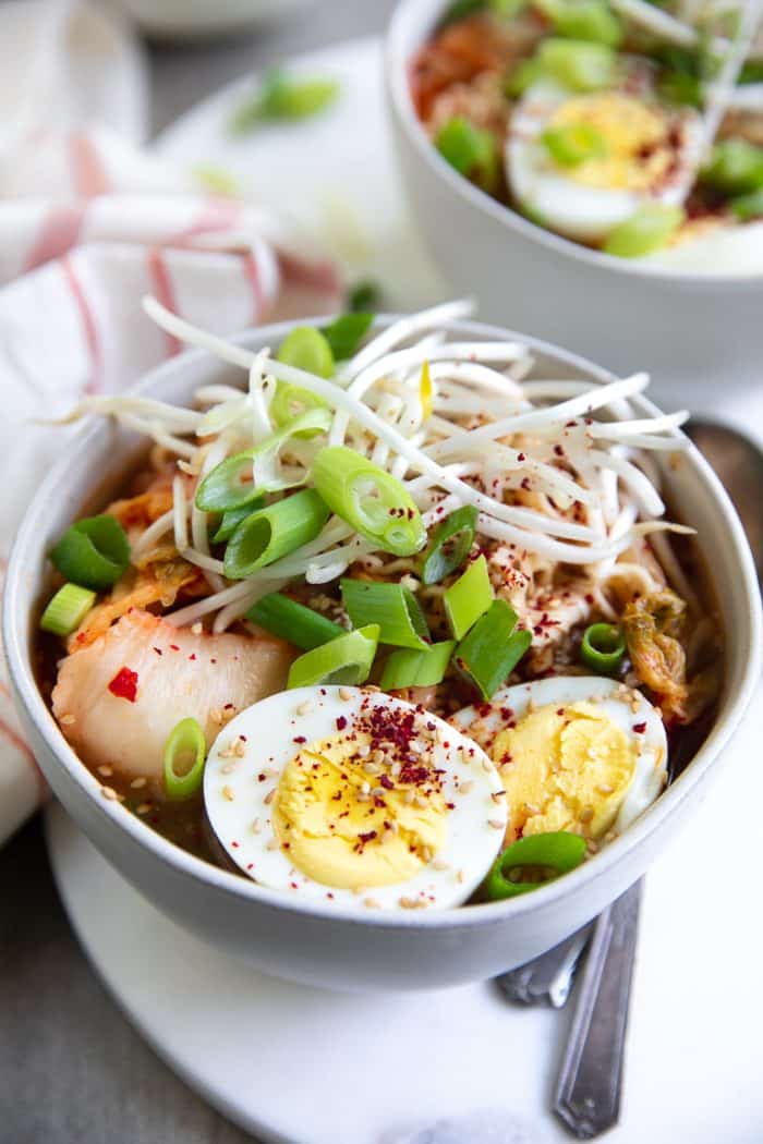 Close-up image of Kimchi Ramen Soup with kimchi, egg, green onion, bung bean sprouts.