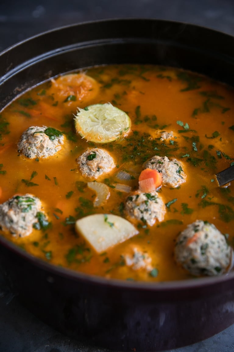 Cooked albondigas soup with carrots, potato, celery, and onion in a rich tomato broth.