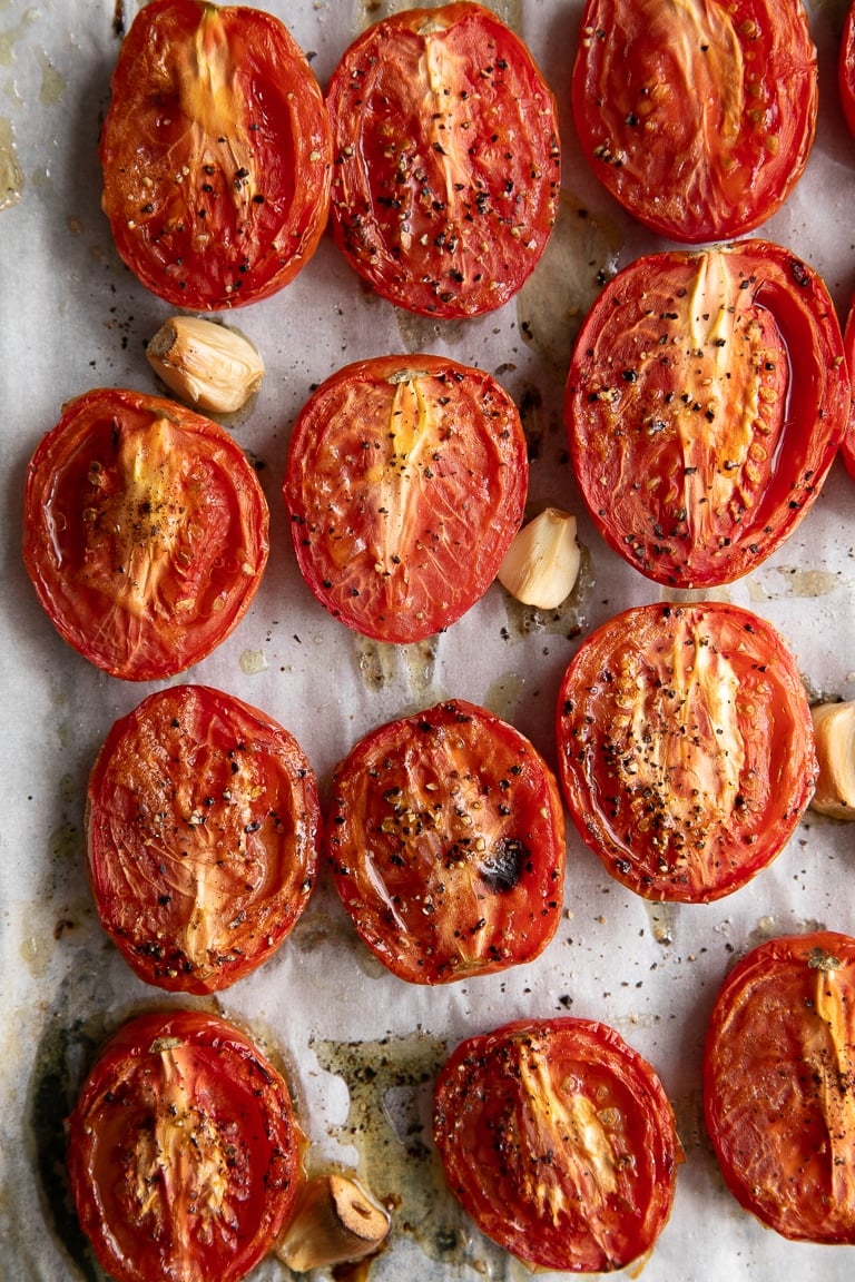Oven Roasted tomatoes and garlic on a sheet pan.
