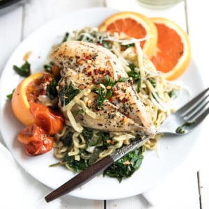 Chicken Linguine on plate with spinach, tomatoes, and orange slices