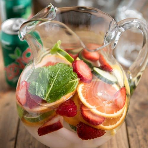 glass pitcher full of fruit and mint