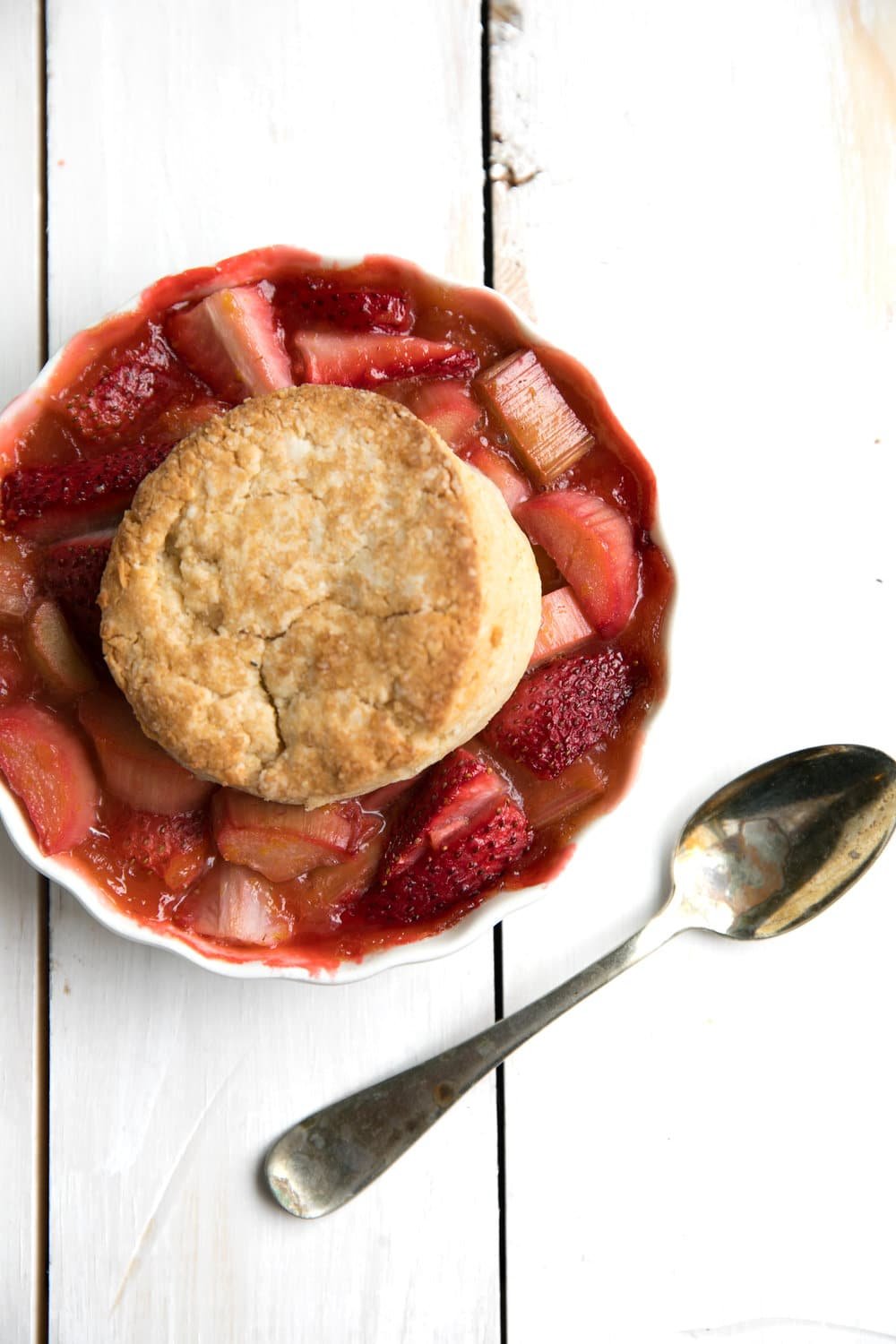 Single serving of Strawberry Rhubarb Cobbler on a white table