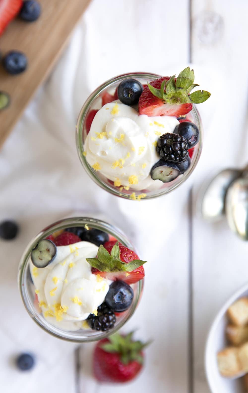 overhead shot of single glasses filled with Berries, Lemon Cake and Honey Lemon Yogurt Mascarpone Cream