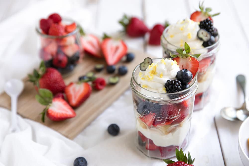 diagonal picture glasses filled with Berries, Lemon Cake and Honey Lemon Yogurt Mascarpone Cream