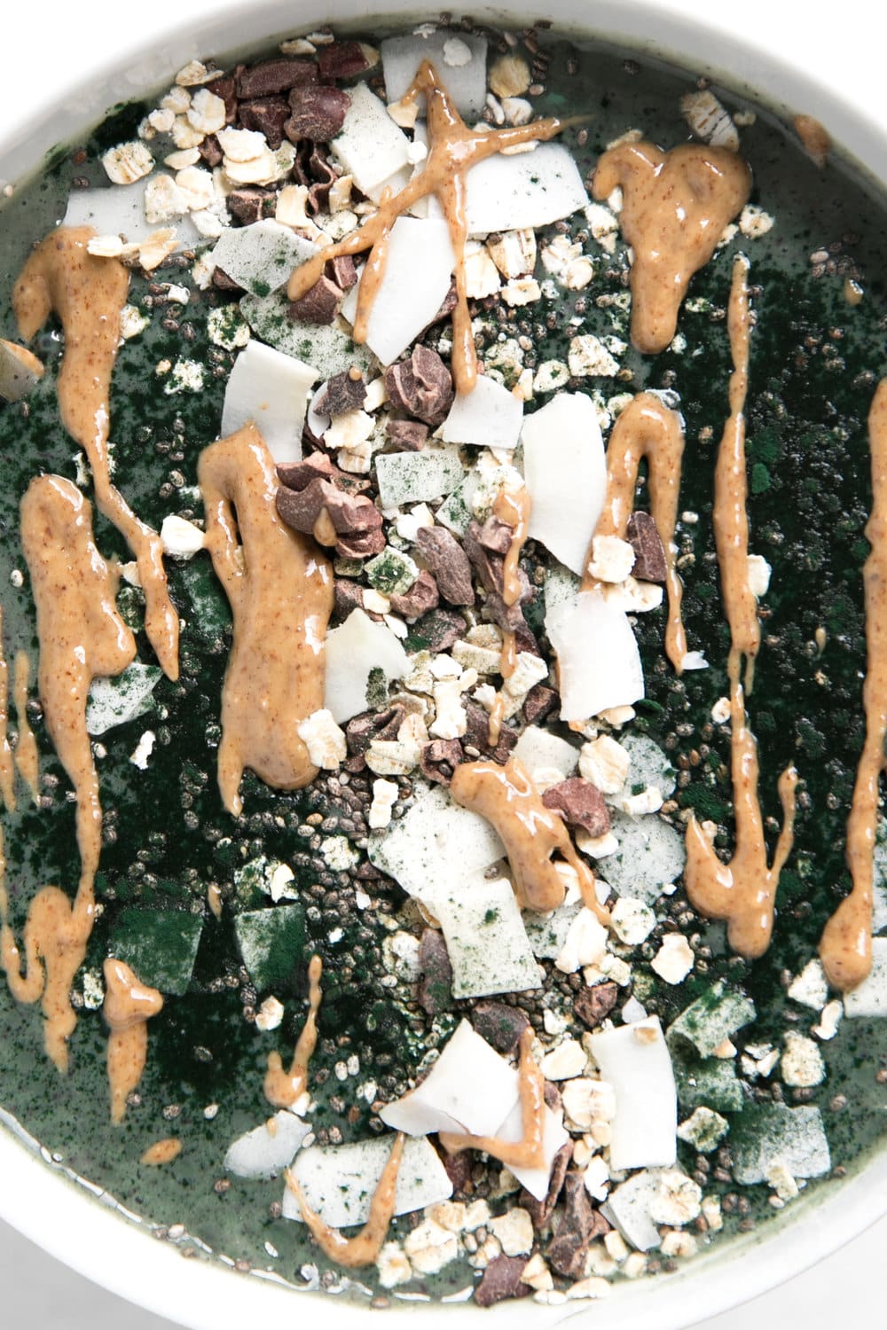 close up of peanut butter drizzle over Almond Butter and Spirulina Smoothie Bowl