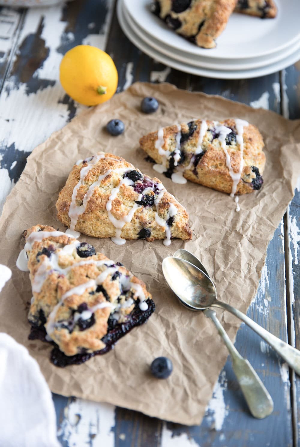 Easy Blueberry Scones on parchment paper on table with lemon