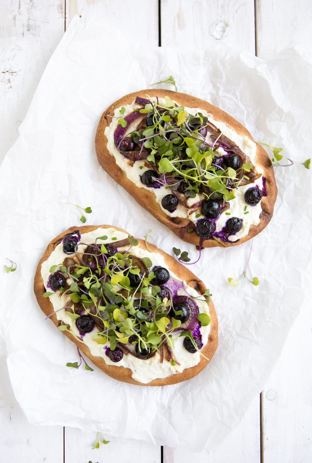 Blueberry and Honey Caramelized Onion Naan Pizza with greens sprinkled
