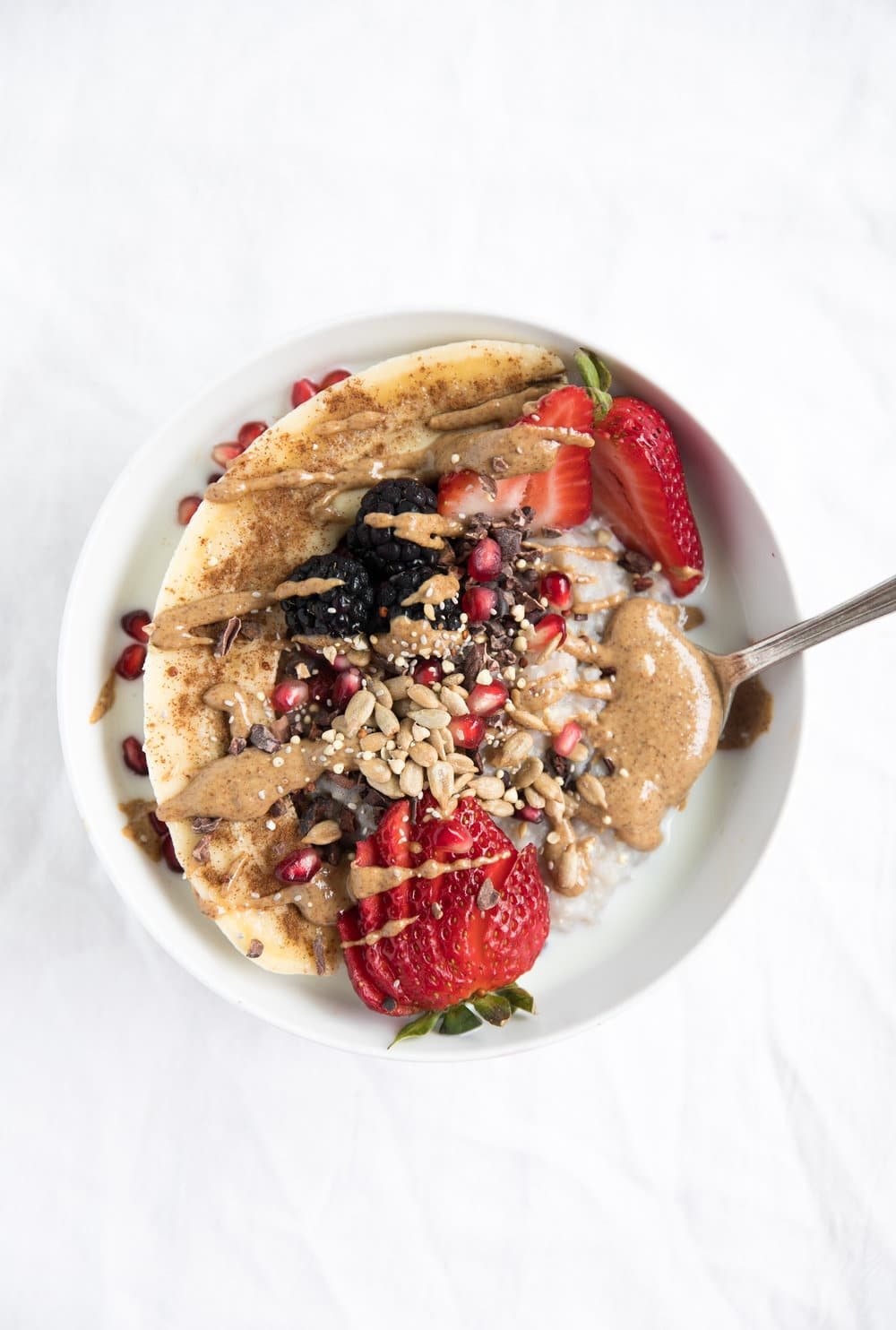 Buckwheat Oatmeal Breakfast Bowl covered in seeds strawberries and peanut butter