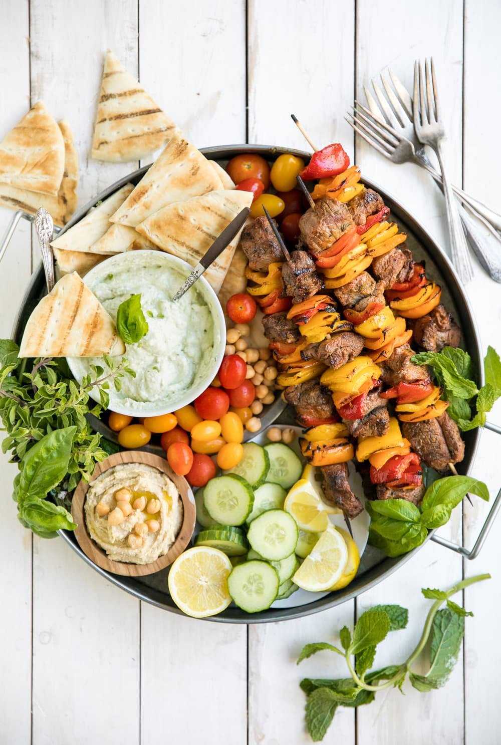 A bunch of food on a plate, with Cheese and Kebab