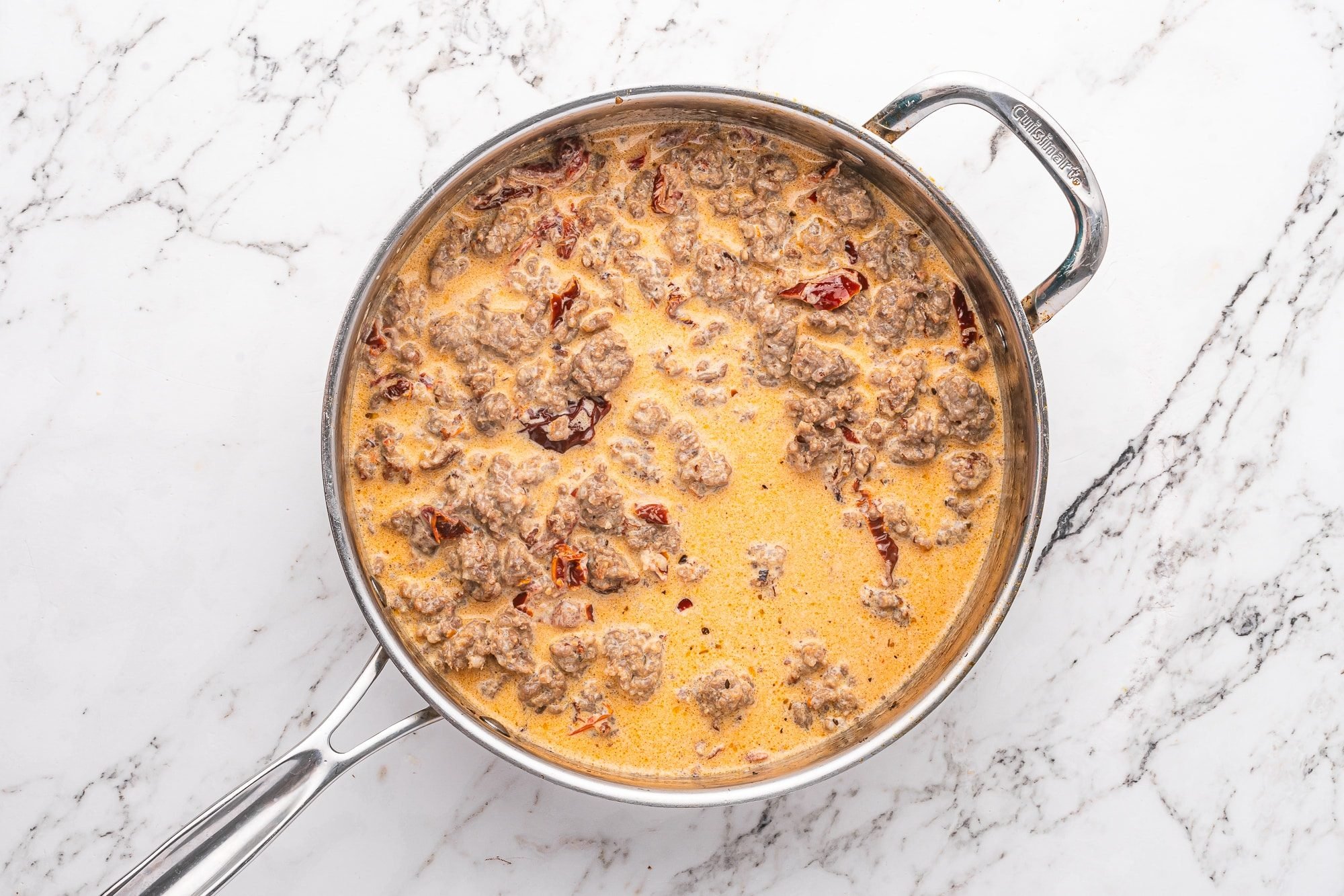 Italian sausage and sun-dried tomatoes simmering in a light orange cream sauce.