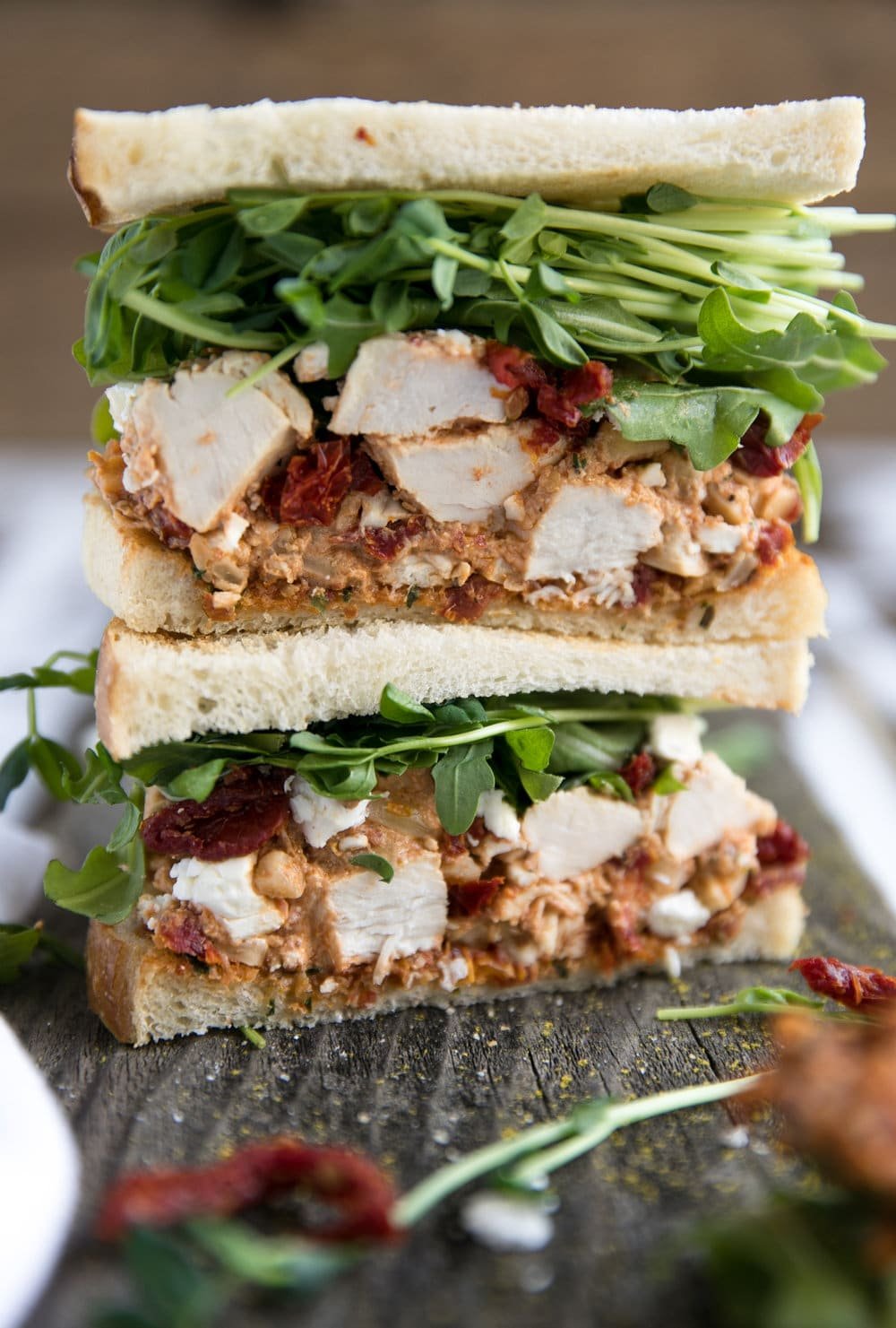 two halves of Sun-Dried Tomato Pesto Chicken Salad Sandwich stacked on eachother