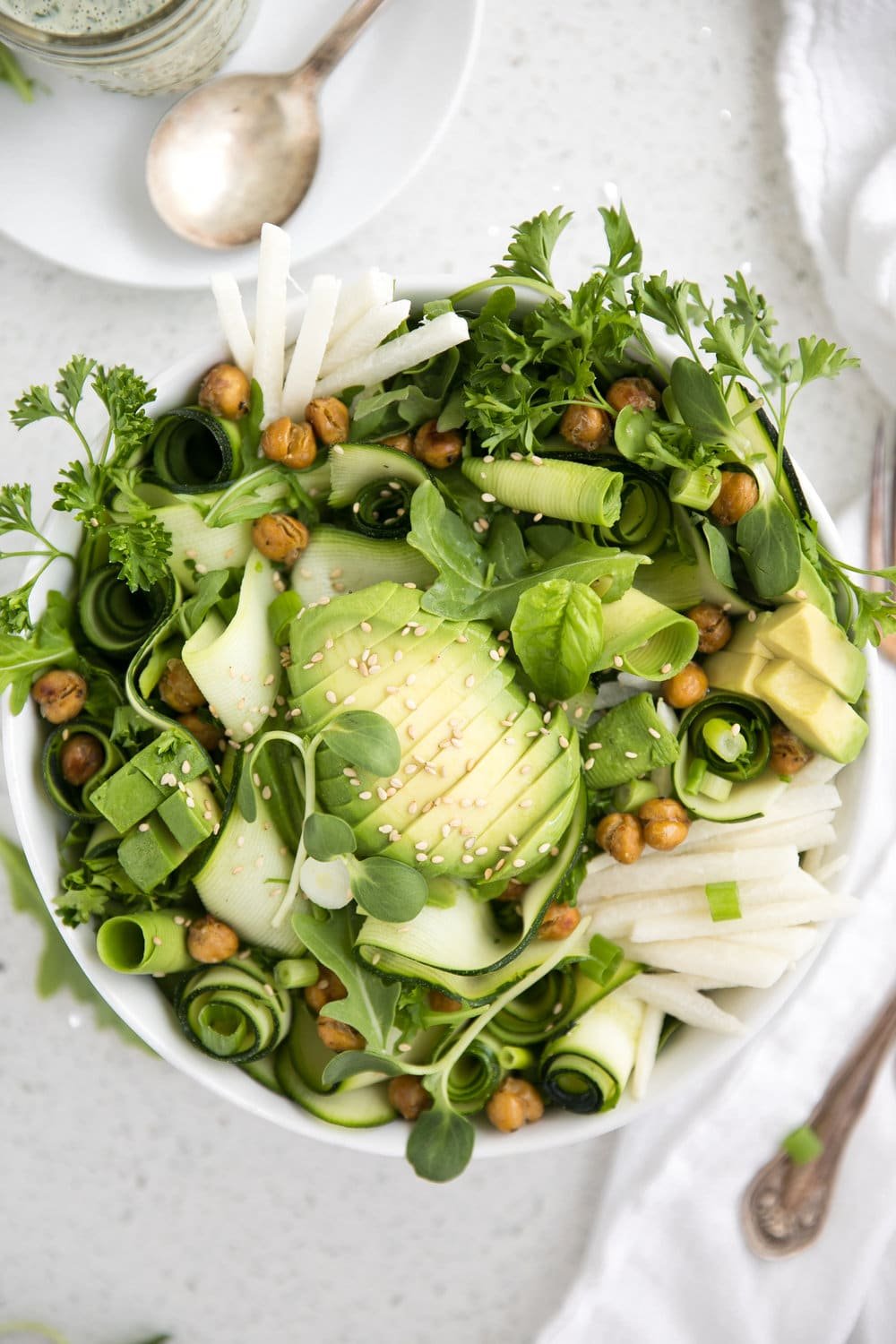 close up overhead photo of zucchini avocado salad with garlic herb dressing and roasted chickpeas