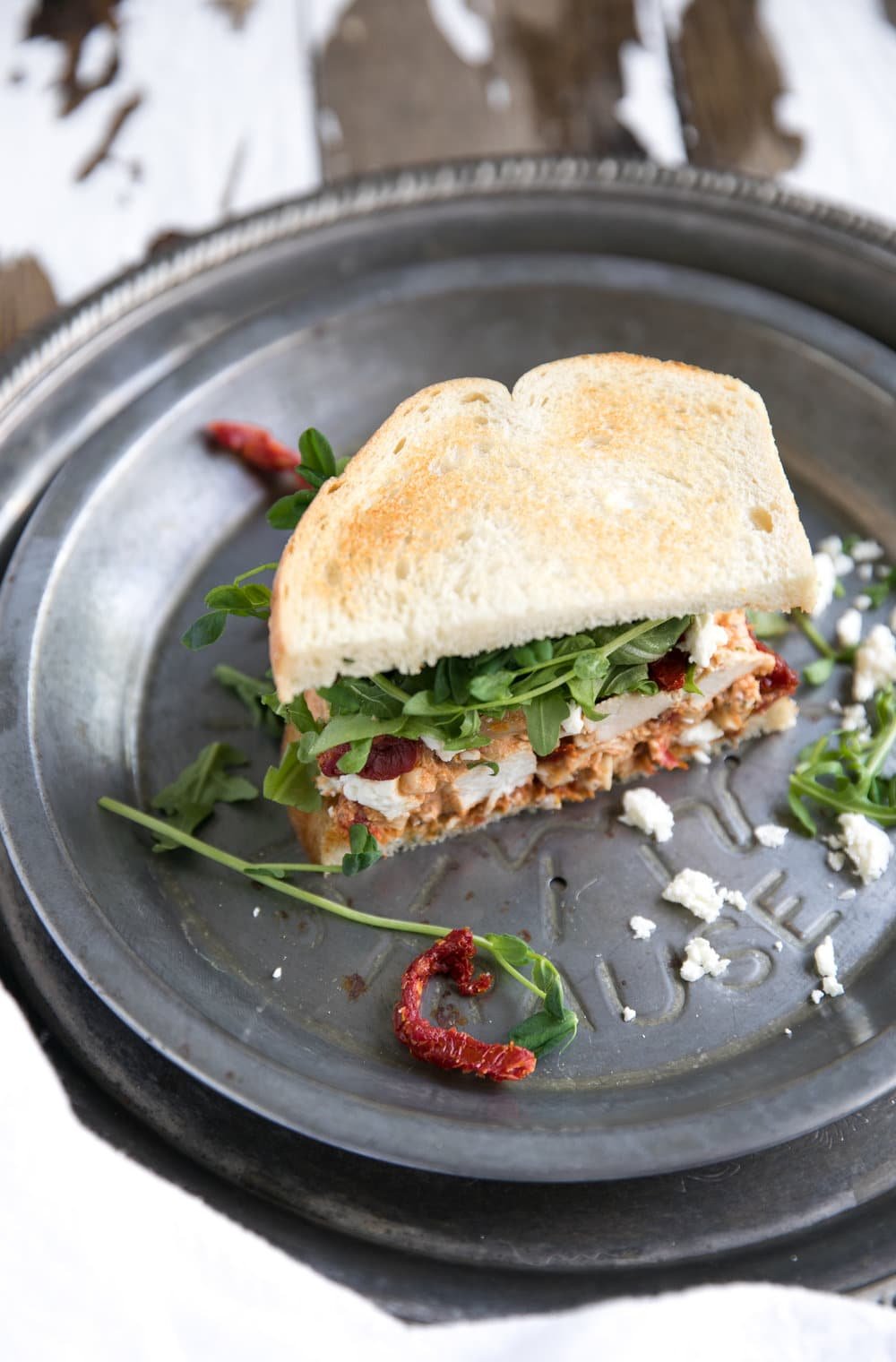 diagonal photo of plated Sun-Dried Tomato Pesto Chicken Salad Sandwich