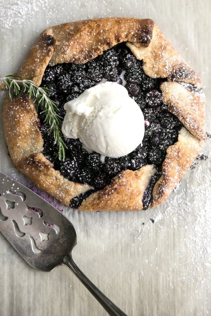 Homemade rustic galette made with blackberries and blueberries and topped with a big scoop of vanilla ice cream.