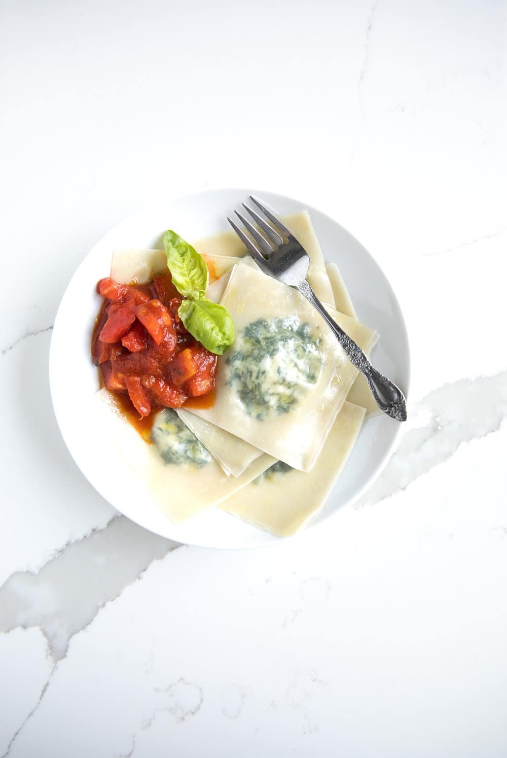 A plate of ravioli with a fork