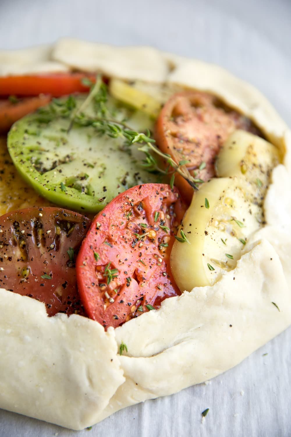 multicolored Heirloom Tomato placed into uncooked Galette