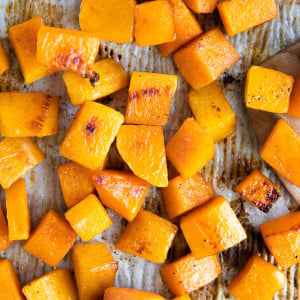 Roasted cubes of butternut squash on a baking sheet.
