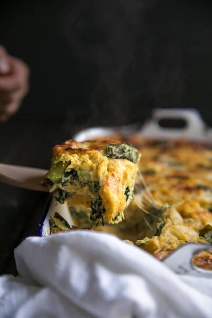 Close-up image of a scoop of steamy butternut squash lasagna being scooped from the pan.