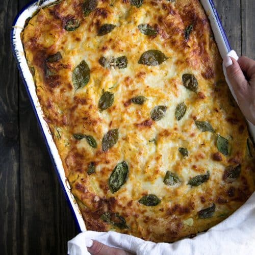 Serving a lasagna made with butternut squash, zucchini, spinach and cheeses in a large casserole dish