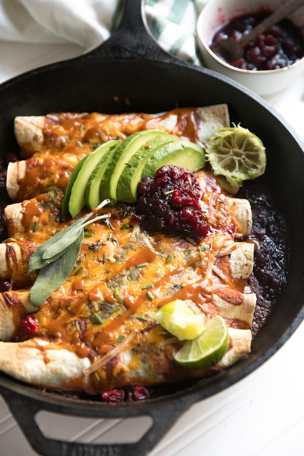 Leftover Thanksgiving Enchiladas filled with turkey, stuffing, leftover vegetable casserole, cheese, and cranberry sauce.
