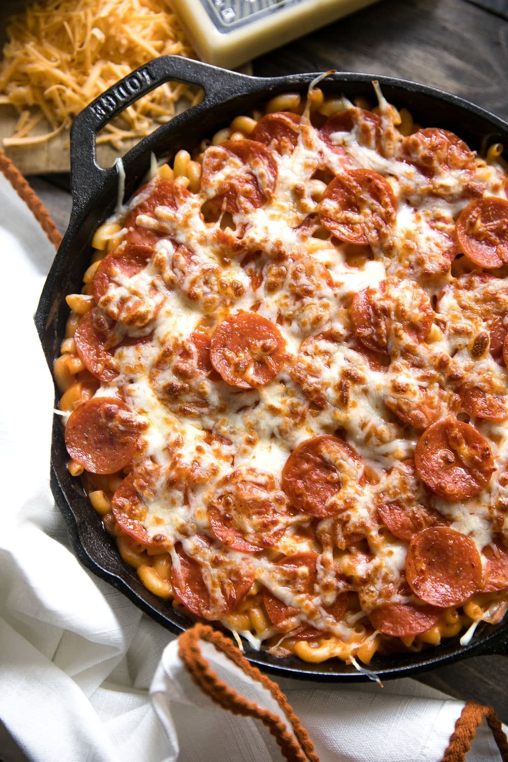 A pizza sitting on top of a pan on a table, with Cheese and Pepperoni