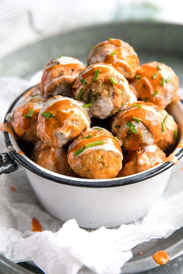 White bowl filled with baked buffalo turkey meatballs