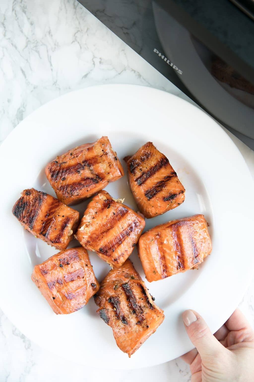 Grilled salmon fillets on a white plate.