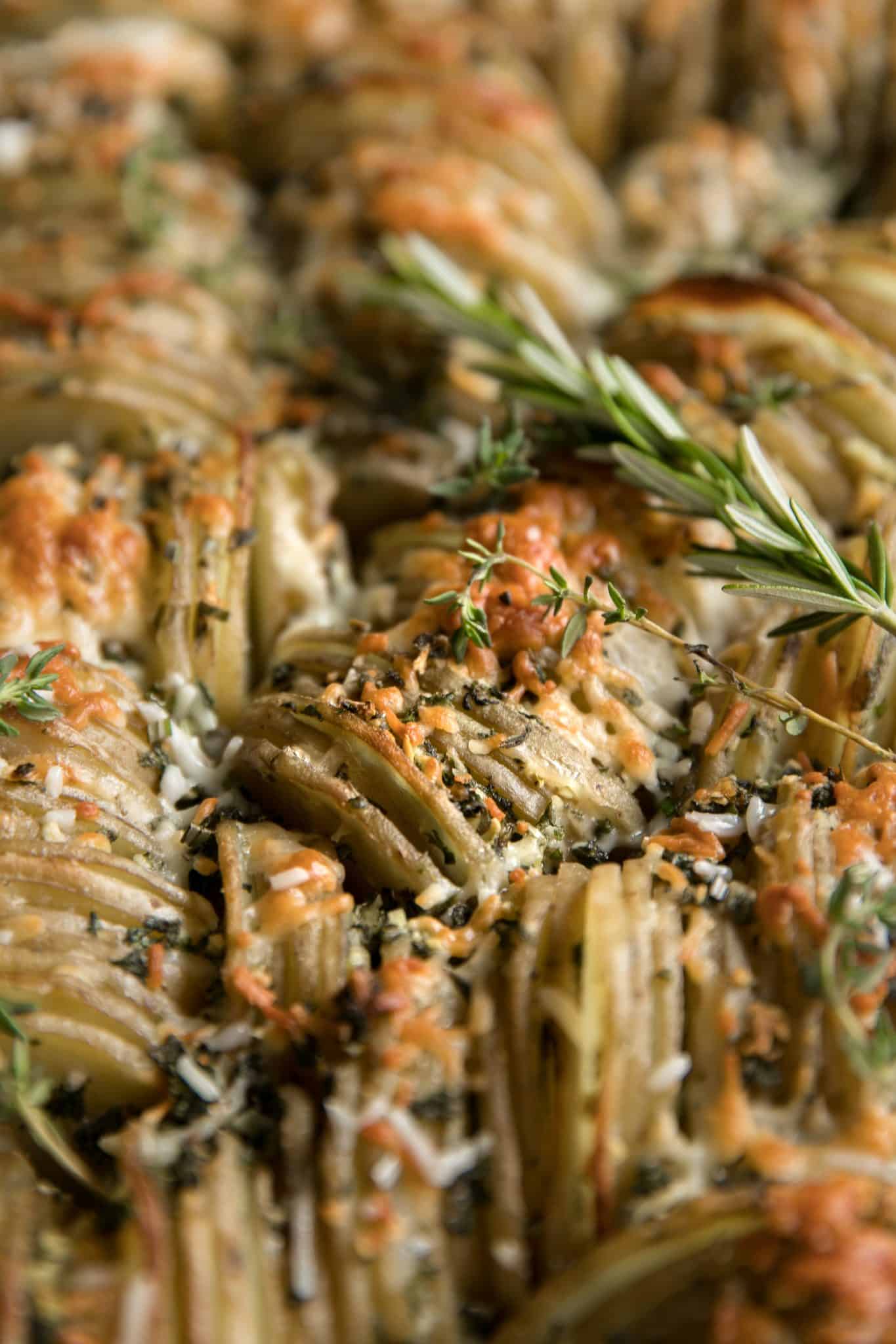 Baking pan filled with thinly sliced potatoes layered with garlic, herbs, butter, and cheese and baked until tender and crispy.