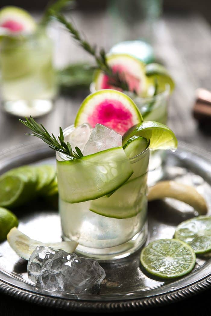 Gin and Tonic with cucumber, rosemary and watermelon radish on an antique tray.